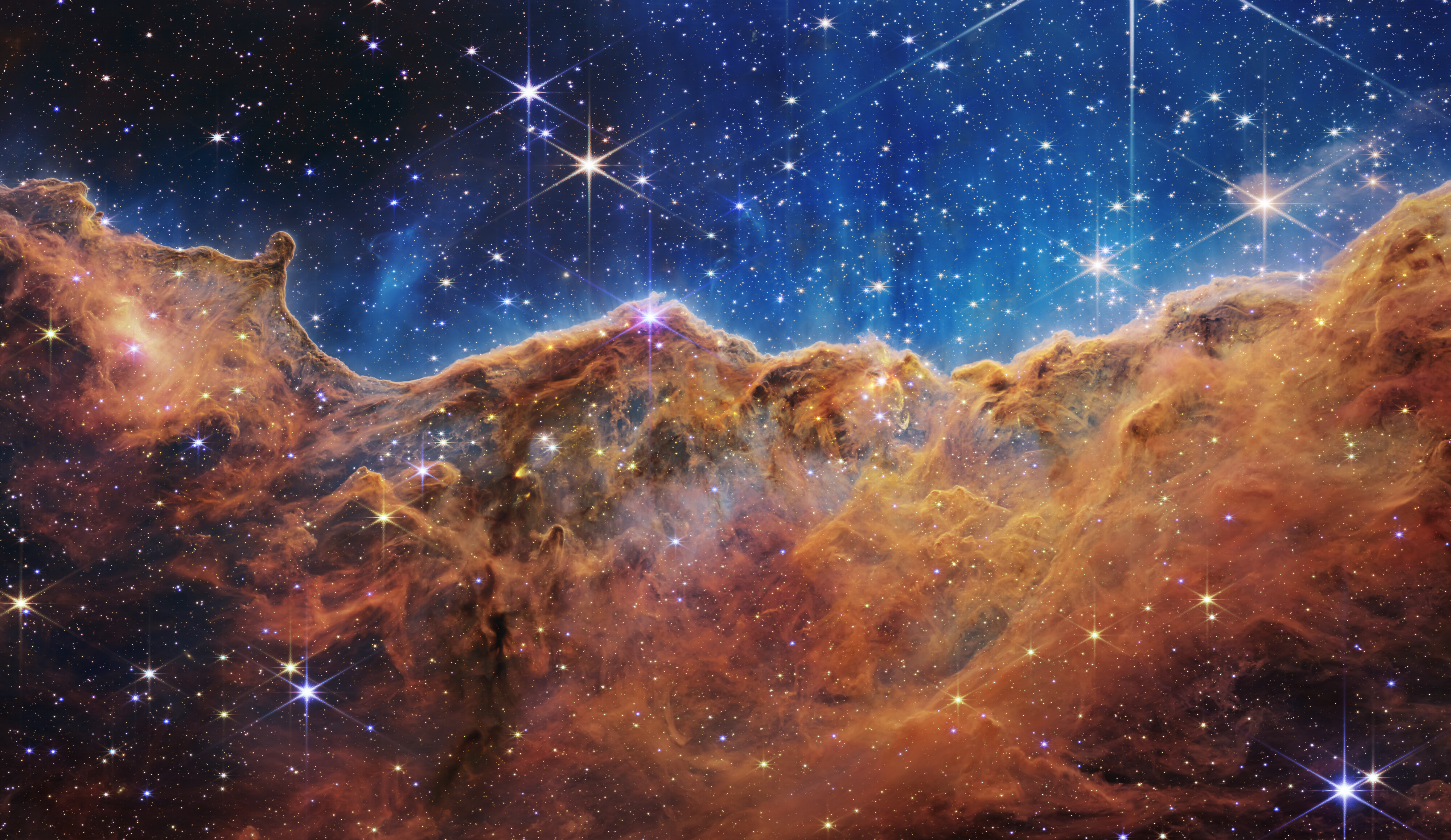 Webb’s infrared view of golden clouds and young stars in the Cosmic Cliffs of the Carina Nebula
